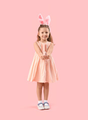 Wall Mural - Cute little girl in bunny ears with bird on pink background. Easter celebration