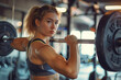 portrait of Young sportswoman using barbell while doing back exercise in gym