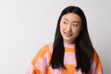 Poster - Portrait of smiling woman on light background. Space for text