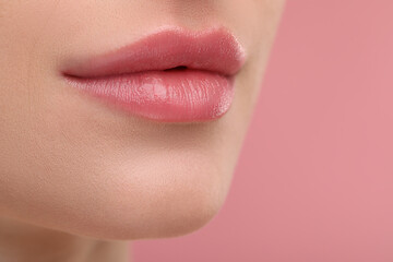 Wall Mural - Young woman with beautiful full lips on pink background, closeup