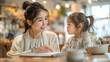 Children education and home school concept : Young beautiful mother pleased to see little daughters' study online sitting on desk at modern home minimal decor.