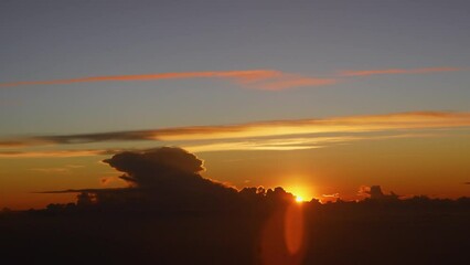 Wall Mural - Sunrise with a height. Dramatic sunset. View of dawn above cumulonimbus cloud from airplane window