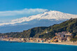 © Art Media Factory - Panoramic view of Taormina shore at Ionian sea with Giardini Naxos and Villagonia towns and Mount Etna volcano in Messina region of Sicily in Italy