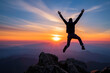 © Emanuel - An excited young businessman jumping with arms raised after reaching the peak of a mountain - Symbolizing success, victory, and leadership concept