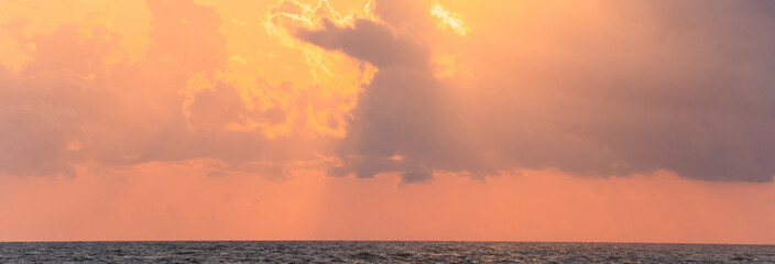 Canvas Print - Red sun behind the clouds over the sea