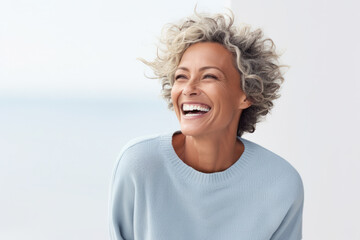 Wall Mural - Joyful mature woman laughing in casual outfit. Happiness and wellbeing.