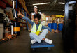 © offsuperphoto - factory workers moving cart and having fun in the warehouse storage