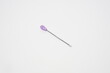 © Anggi S Gunawan - ear pick made of stainless steel with a purple plastic handle from the side angle on a white background