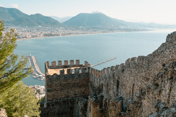 View from the ancient fortress wall to the sea coast and the city with the port. Beautiful tourist landscape.
