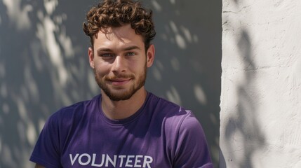 Wall Mural - Young man with curly hair and beard wearing a purple t-shirt with the word 