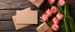 A bouquet of pink tulips placed next to a blank card and envelope on a grunge wooden background. Perfect for expressing love, gratitude, or well-wishes.