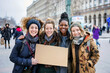 Groupe diversifié de femmes souriantes et heureuses tenant une pancarte vide pour la pour la Journée internationale de la femme