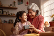 © AJay - Indian ethnic grandmother and granddaughter having a fun time inside their home