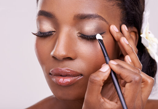black woman, face and brush for eyeshadow with beauty, makeup and lashes on grey background. skin gl