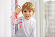Cute child, blond boy, playing with white and red bracelet, martenitsa