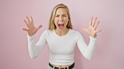 Sticker - Frustrated young blonde woman, madly yelling with an aggressive expression and raised arms over an isolated pink background. crazy manifestation of anger and stress in a stand position.