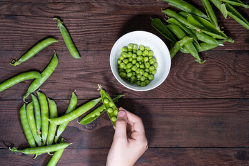 Wall Mural - Ripe green peas on a wooden table.