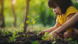 Asian little girl planting young tree on black soil together as save world concept in vintage color tone. 