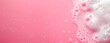 washroom background with foam and bubbles, on a pink bathroom surface, horizontal wallpaper wellnes, refreshment and cosmetics concept, copy space for text