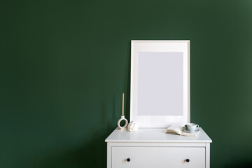 Wall Mural - Empty picture in frame on white drawer dresser on green wall background