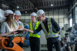 © ultramansk - team engineers inspecting on machine with smart tablet. Worker works at heavy machine robot arm. The welding machine with a remote system in an industrial factory. Artificial intelligence concept.