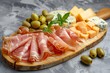 Antipasti snack with Prosciutto Parmesan Blue cheese Cantaloupe melon and Olives on wooden board with concrete background