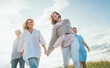 © Soloviova Liudmyla - Portrait of four cheerful smiling women holding hand in hand walking by a high green grass meadow. They looking at the camera. Woman's friendship, relations, and happiness concept image.