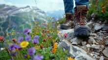 A Closeup Shot Of Hiking Boots On A Narrow Mountain Path Showing The Rocky Ground And Vibrant Wildflowers Blooming Alongside.
