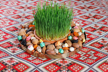 Canvas Print - Traditional Azerbaijan holiday Novruz background with green semeni,traditional azerbaijan sweets,shekerbura,qogal,paxlava,mutaki and different nuts and sweets,top view,space for copy