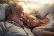 An elderly man and woman lay side by side in bed, their expressions showing love and tenderness