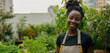 © NOWO - Portrait of a beautiful woman in an urban garden. A female student is learning and working, taking care of vegetable plants and seedlings. Banner with copy space.
