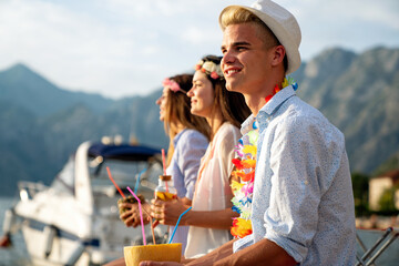 Happy friends having fun with tropical cocktails on beach party. Travel and summer vacation concept.