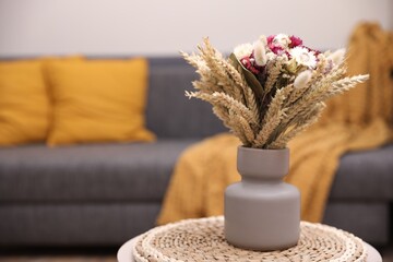 Canvas Print - Bouquet of beautiful dry flowers and spikelets in vase on side table at home. Space for text