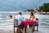 Fototapeta Panele - Couple in love drinking wine on romantic dinner at sunset on the beach.