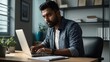 © LIFE LINE - Indian male employee in casual shirt engrossed in work at his office, using a laptop and reviewing paperwork with focus