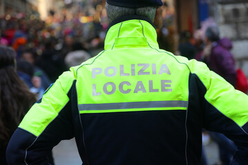 Wall Mural - Italian city with policeman on guard with text on uniform meaning Local Police