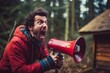 Man with crazy eyes shouts into a red loudspeaker in a remote forest, but no one hears him.