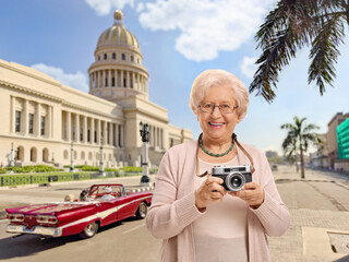 Sticker - Elderly female tourist with a vintage camera in Havana