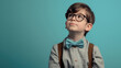 Little boy in glasses and a bow tie on a blue background. Education, elementary school and people concept