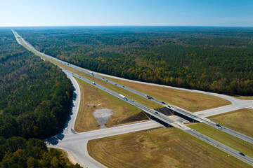 Poster - Aerial view of freeway overpass junction with fast moving traffic cars and trucks in american rural area. Interstate transportation infrastructure in USA