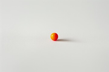 A vibrant red candy stands out against a pure white backdrop, invoking feelings of desire and temptation