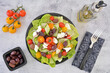 Greek salad on stone background in flat lay