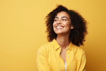 Wall Mural - Beautiful african american woman smiling and looking away over yellow background