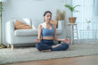 © ultramansk - Two women confident training yoga. Athletic women in sportswear doing fitness stretching exercises at home in the living room. Sport and recreation concept. Yoga teacher is helping young woman.