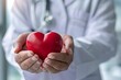 © Jelena - Heartfelt healthcare concept Doctor's hand gently holding a heart Symbolizing care Compassion And dedication in the medical field