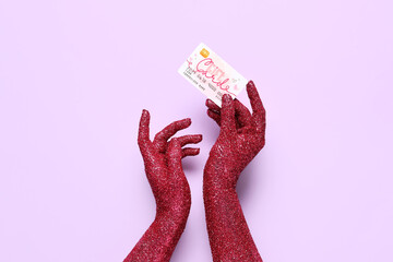 Sticker - Female hands covered with glitter and gift card on lilac background, closeup