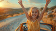 © Fokke Baarssen - happy child girl goes to a summer travel trip in the car, a summer road trip at sunset, kid with hands up