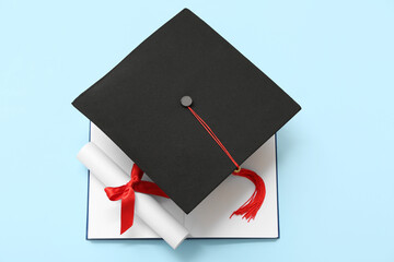 Wall Mural - Graduation hat with diploma and notebook on blue background