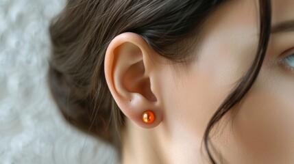 Wall Mural - Close-Up of a Woman's Ear with Orange Jewelry Generative AI