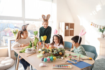 Canvas Print - Cute little children in bunny ears making Easter crafts at table